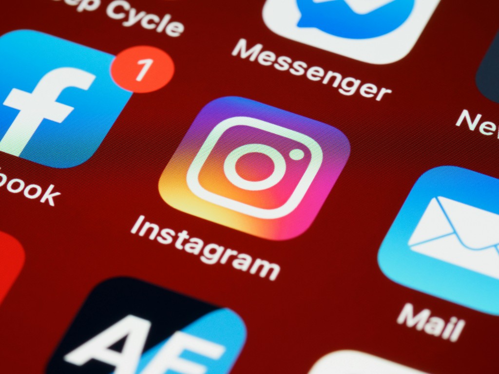Phone screen showing Instagram, Facebook, Messenger, and related social apps for Meta advertising