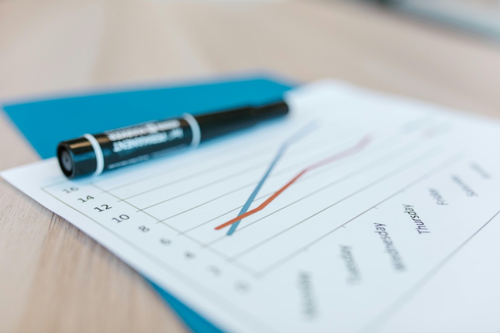Printed line chart on a desk showing daily performance trends through the week