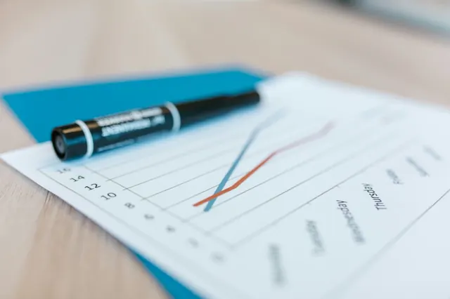 Printed line chart on a desk showing daily performance trends through the week